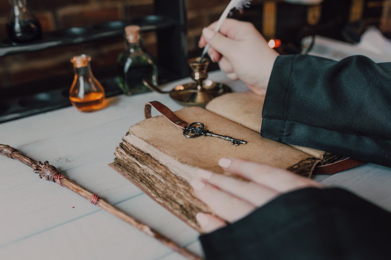 contact-img Mystical setup with a quill, spell book, and magical potions.