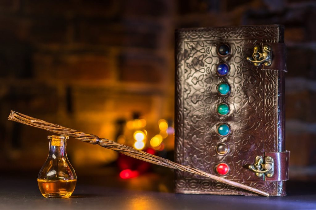 pexels photo 7978819 Close-up of a wizard's wand and potion with a magical spell book on a rustic background.