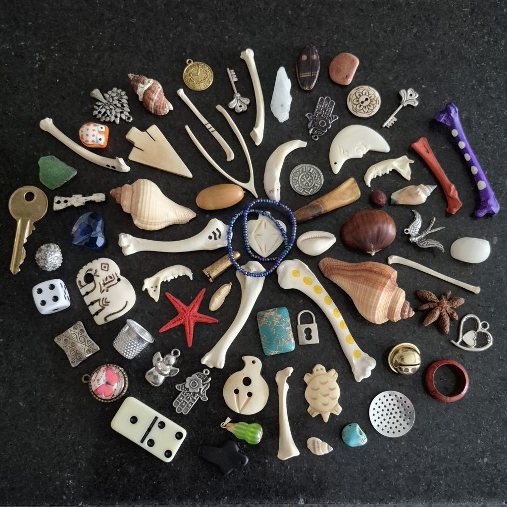 The Crossroad Witch's personal bone reading set An image of the site owners personal bone reading set, arranged in an aesthetically pleasing circle on a black marble background.